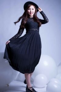 Eterna long black dress with lace sleeves and a pleated skirt.